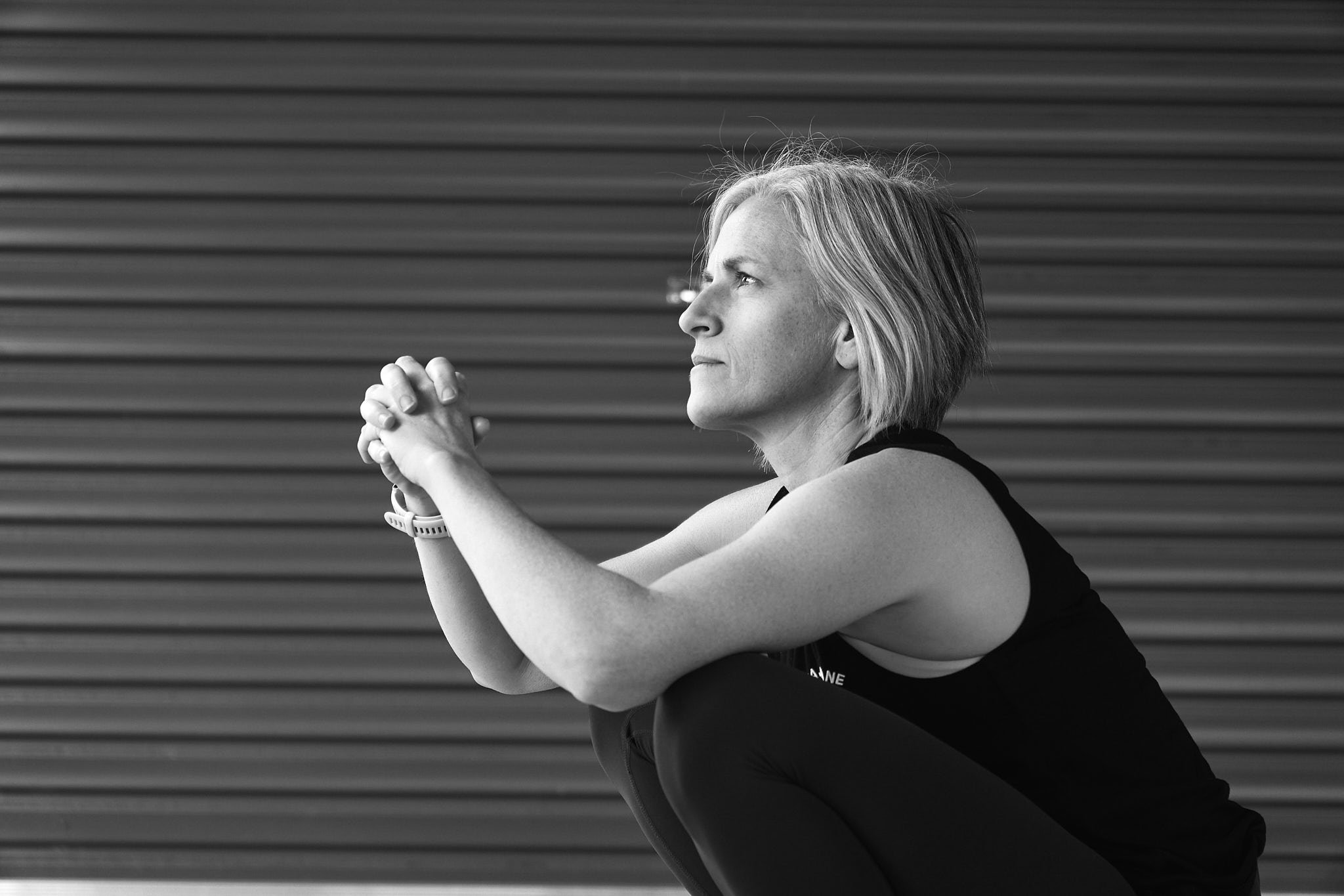 a woman over 40 sitting in a deep squat doing belly breathing exercises
