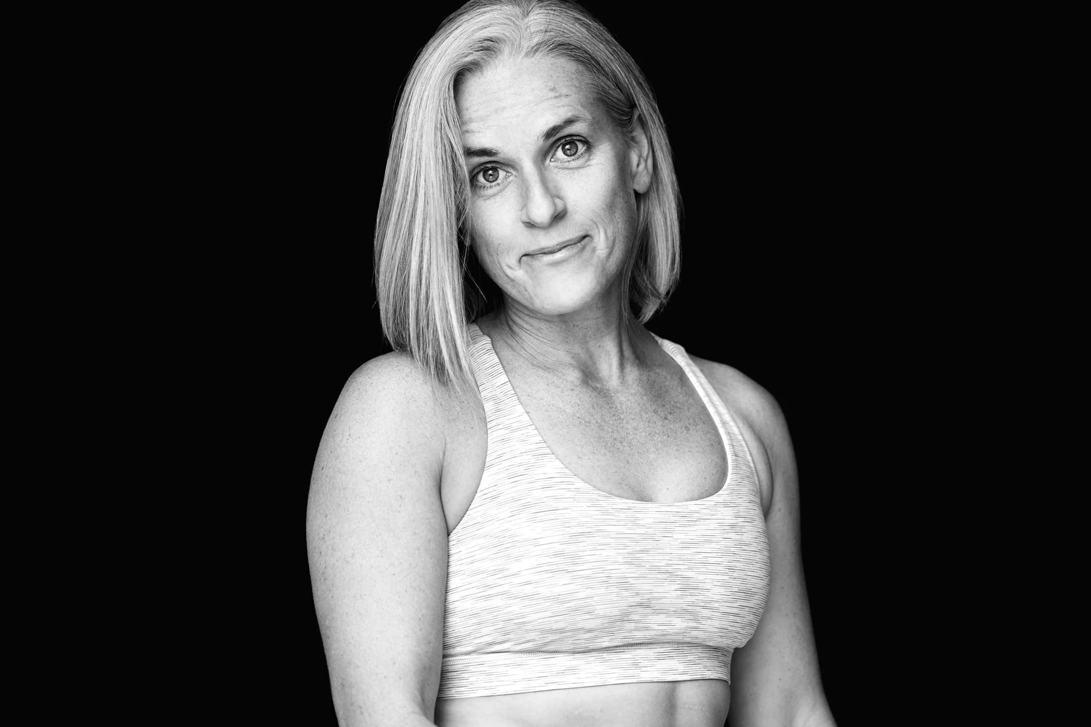 woman in crop top smirking ready for strength training dumbbells