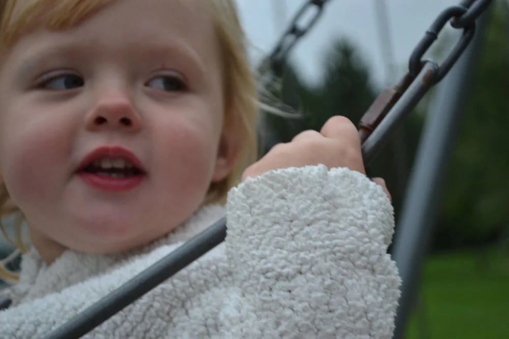 Nikon D3100. How do I get her face in focus, not her hand?