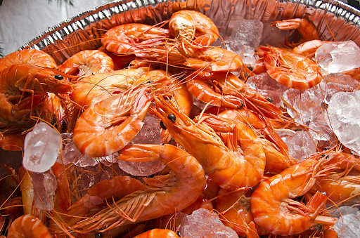 Raw shrimp piled on ice at a seafood counter