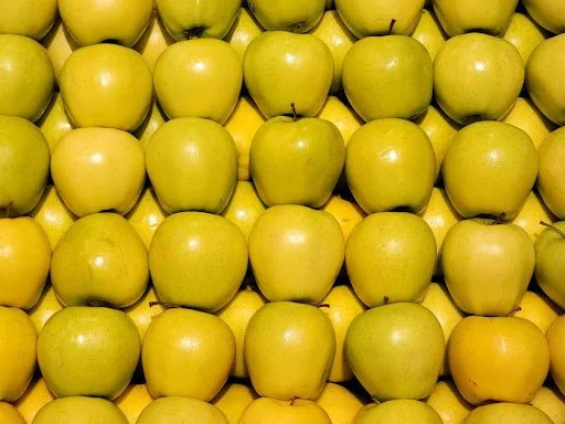 Golden Delicious apples with smooth yellow skin grouped together