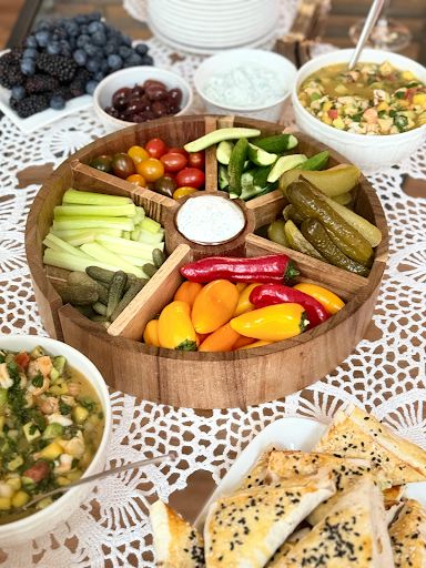 Party platter with fresh vegetables, dips, and snacks arranged on a table