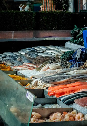 Fresh seafood display with fish, shellfish, and crab legs on ice at a market