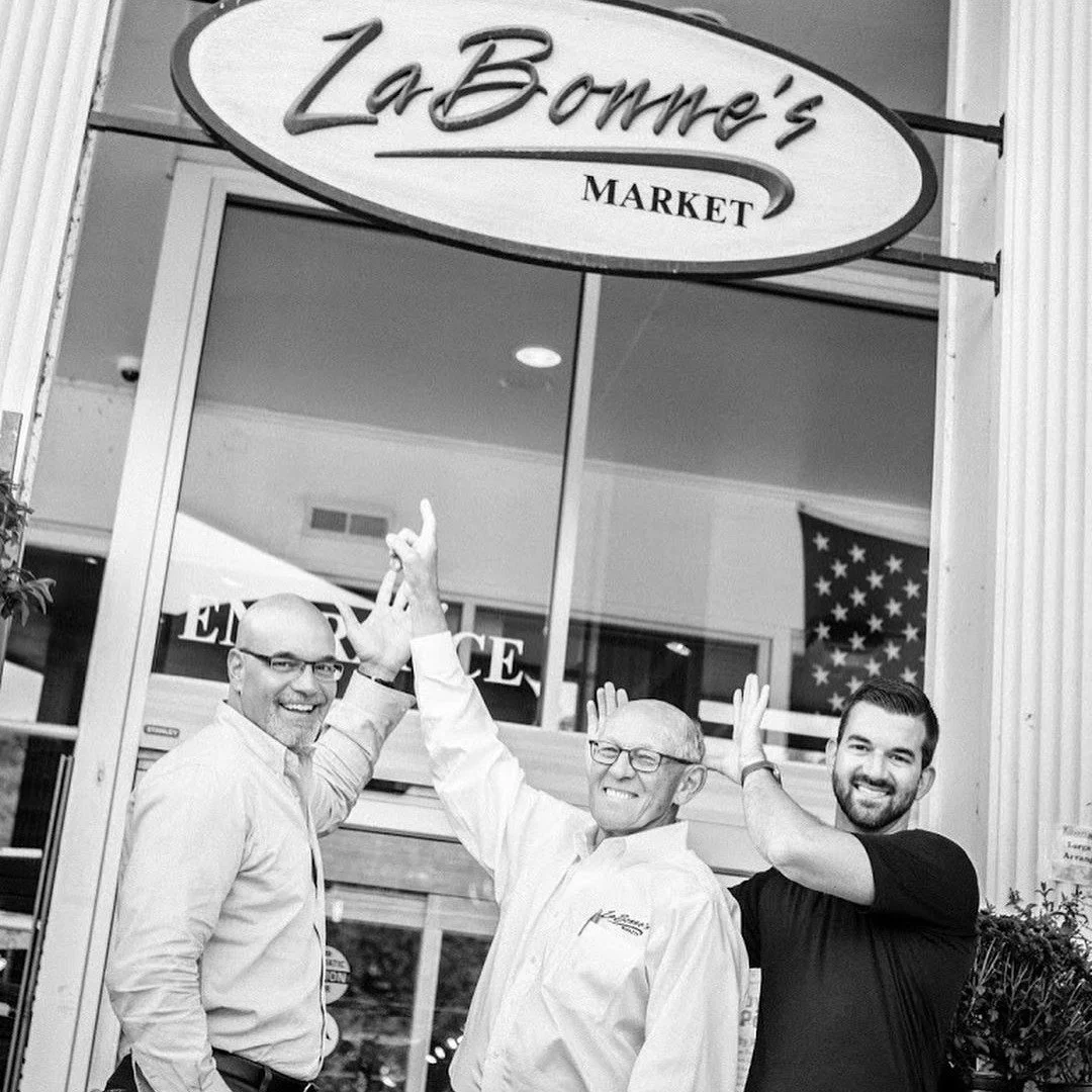 Bob Sr, Bob Jr, and Rob LaBonne standing in front of Woodbury LaBonne's entrance
