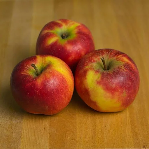 Honeycrisp apples with red and yellow skin on a wooden surface