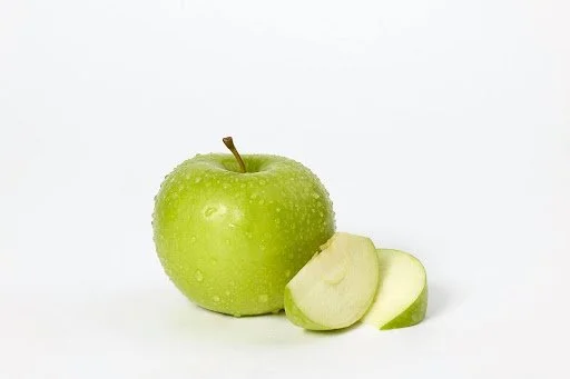 Granny Smith apples with bright green skin, whole and sliced