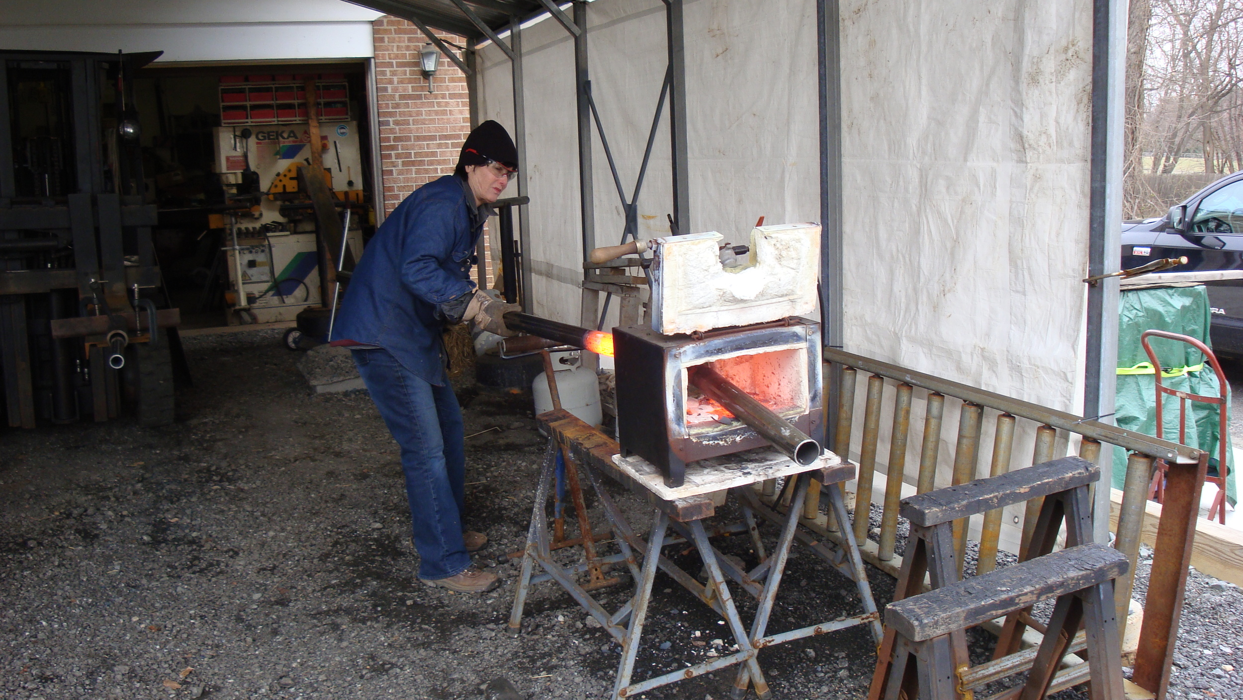 Steel tubes are being bent and shaped in a forge