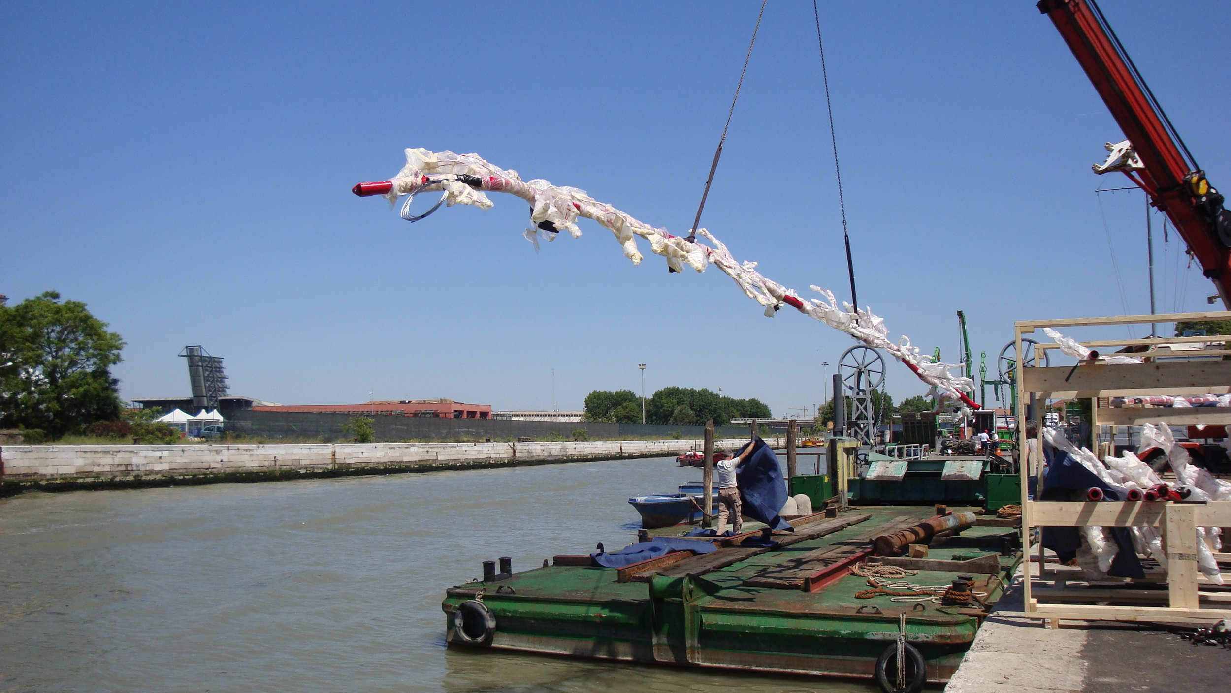 Two main ROOTS are lifted and placed on a barge that will be on its way to the Arsenale