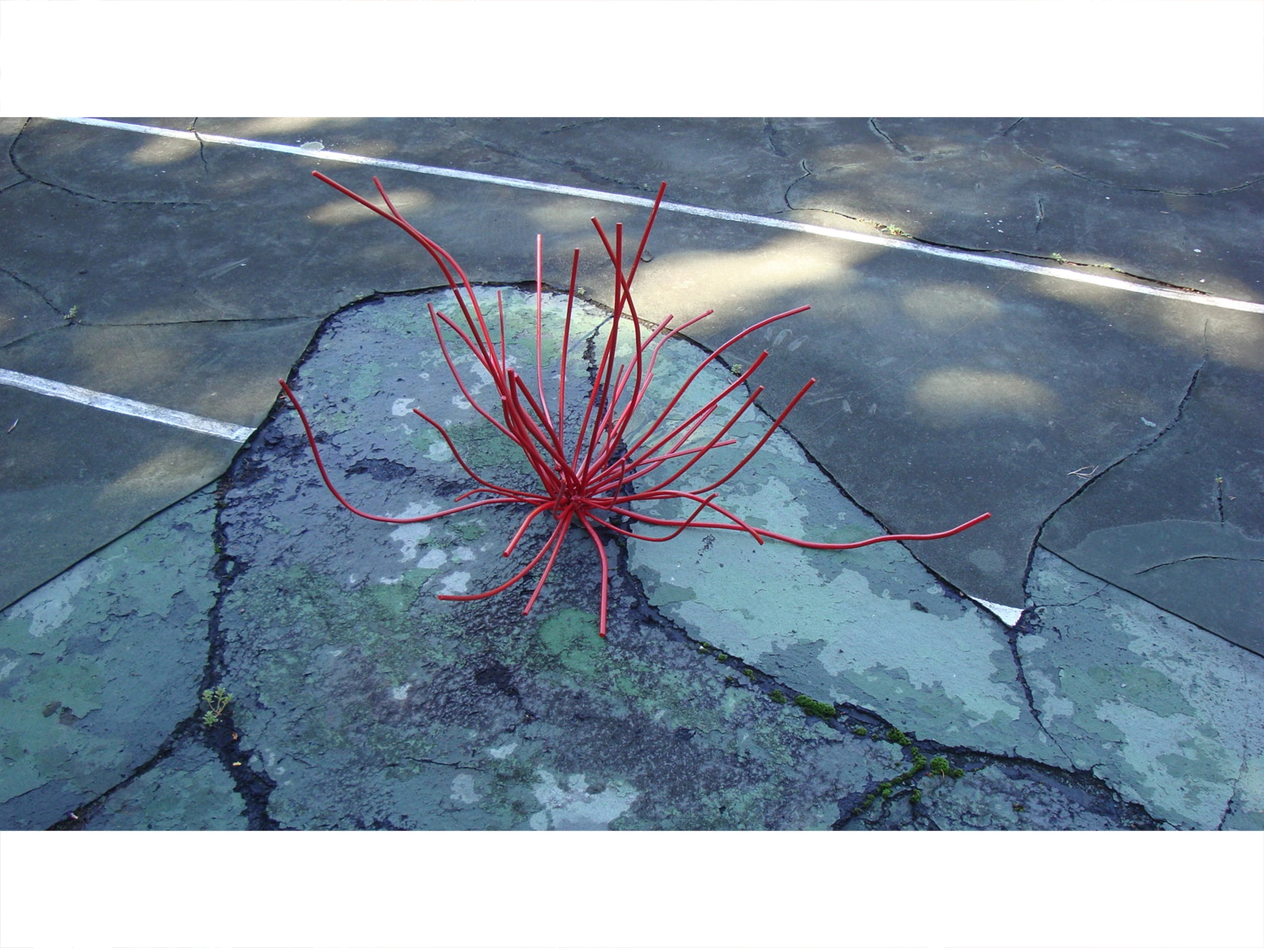 A small metal red ROOT sculpture on the broken floor