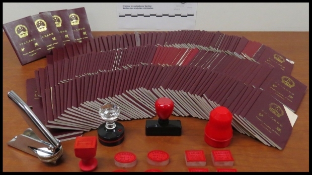 Seized passports and stamps used in the immigration scam by New Can Consulting displayed by Canada Border Services Agency. (CBSA)