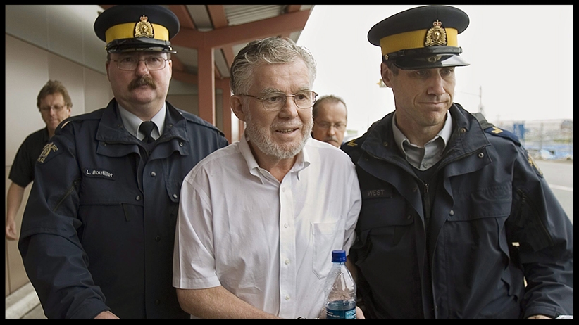 Ernest Fenwick MacIntosh is escorted in custody by RCMP officers at Robert L. Stanfield International Airport in Halifax on Thursday, June 7, 2007 . (Andrew Vaughan/CP)