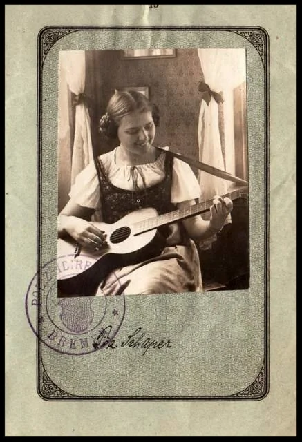 This 1921 German passport shows a young woman with her guitar.
