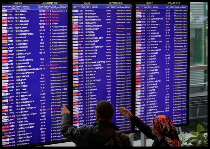 Passengers check the departure board at the Domodedovo Airport outside Moscow, Russia September 28, 2017. 