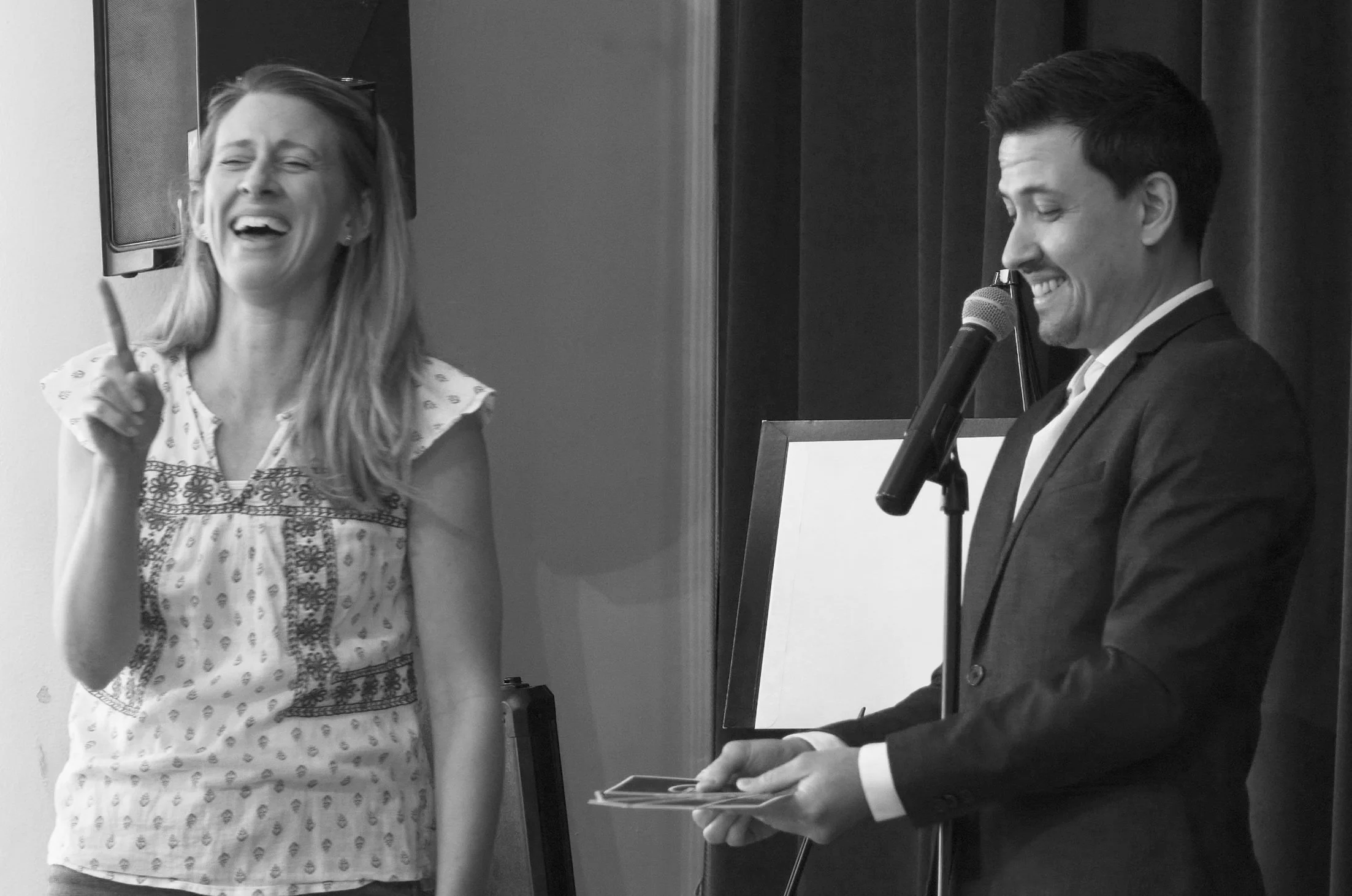 Christopher Moro performing a stand-up stage show with a laughing volunteer on stage in Southern California