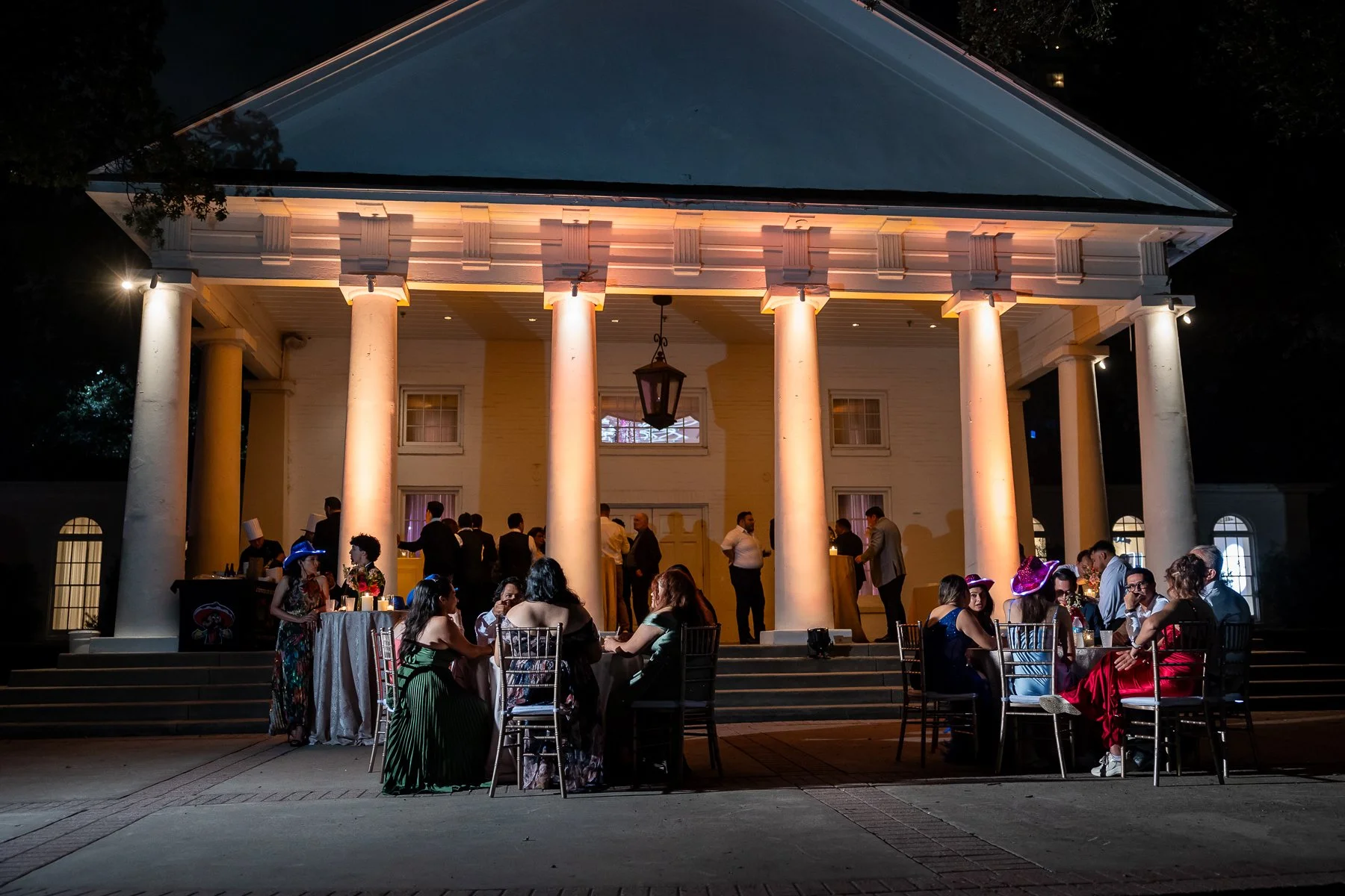 Guests outside the illuminated Arlington Hall at Turtle Creek during a wedding reception in Dallas.