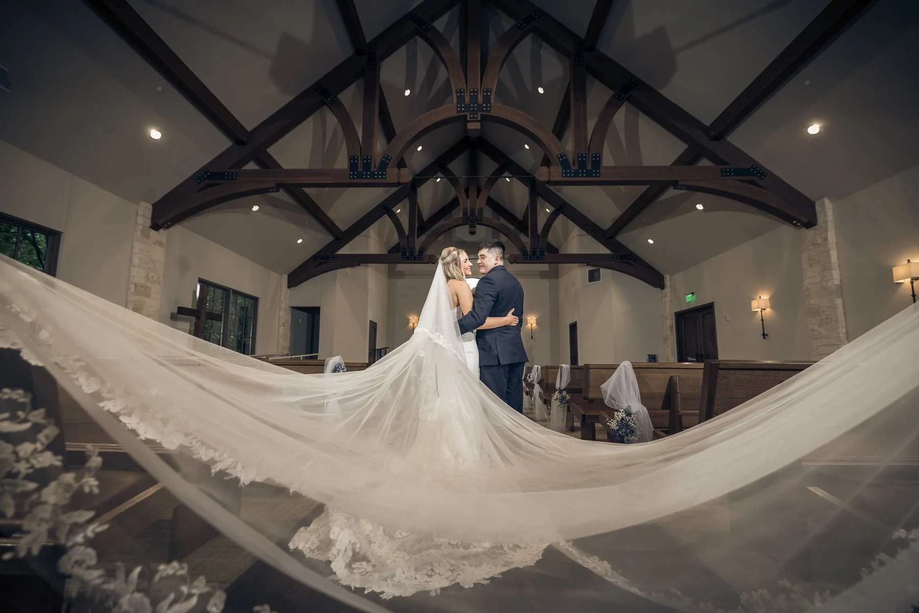 Bride and groom wedding portrait beneath a long veil inside The Laurel chapel.