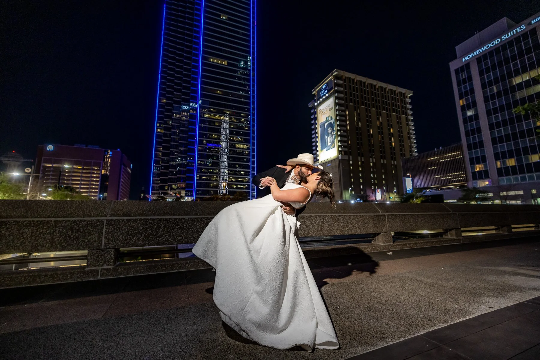 Bride and groom wedding portrait with the Dallas skyline at The Westin Dallas Downtown captured by Rafael Serrano Photography