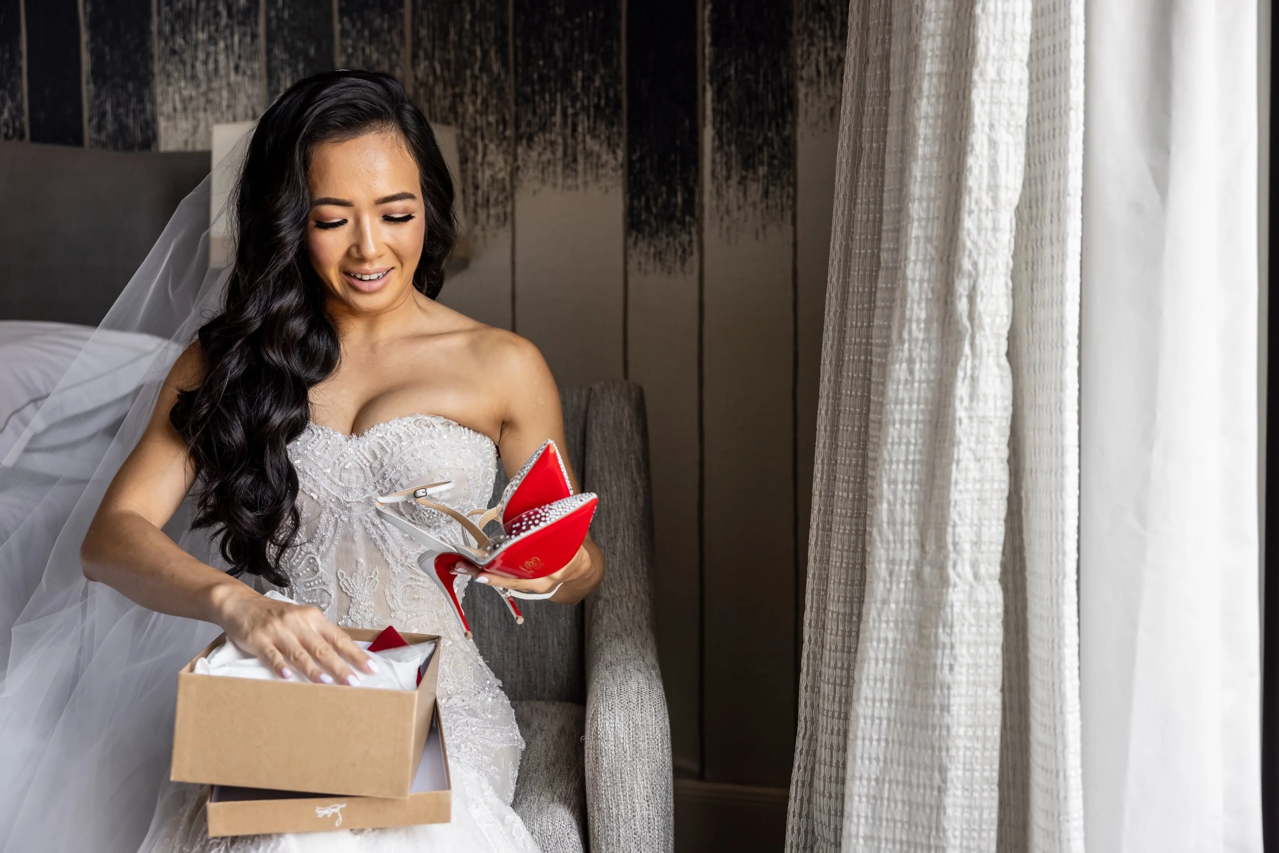 Bride holding wedding shoes while getting ready for her wedding.