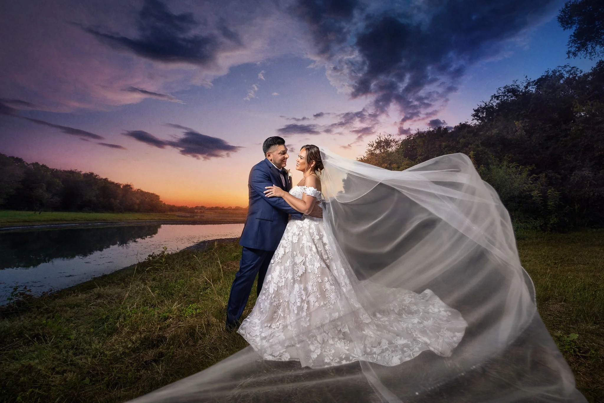 Bride and groom embracing beside a lake at sunset in Dallas, Texas.