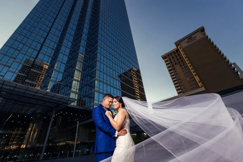 Bride and groom embracing with the Dallas skyline and Tower Club surroundings behind them in Dallas, Texas.