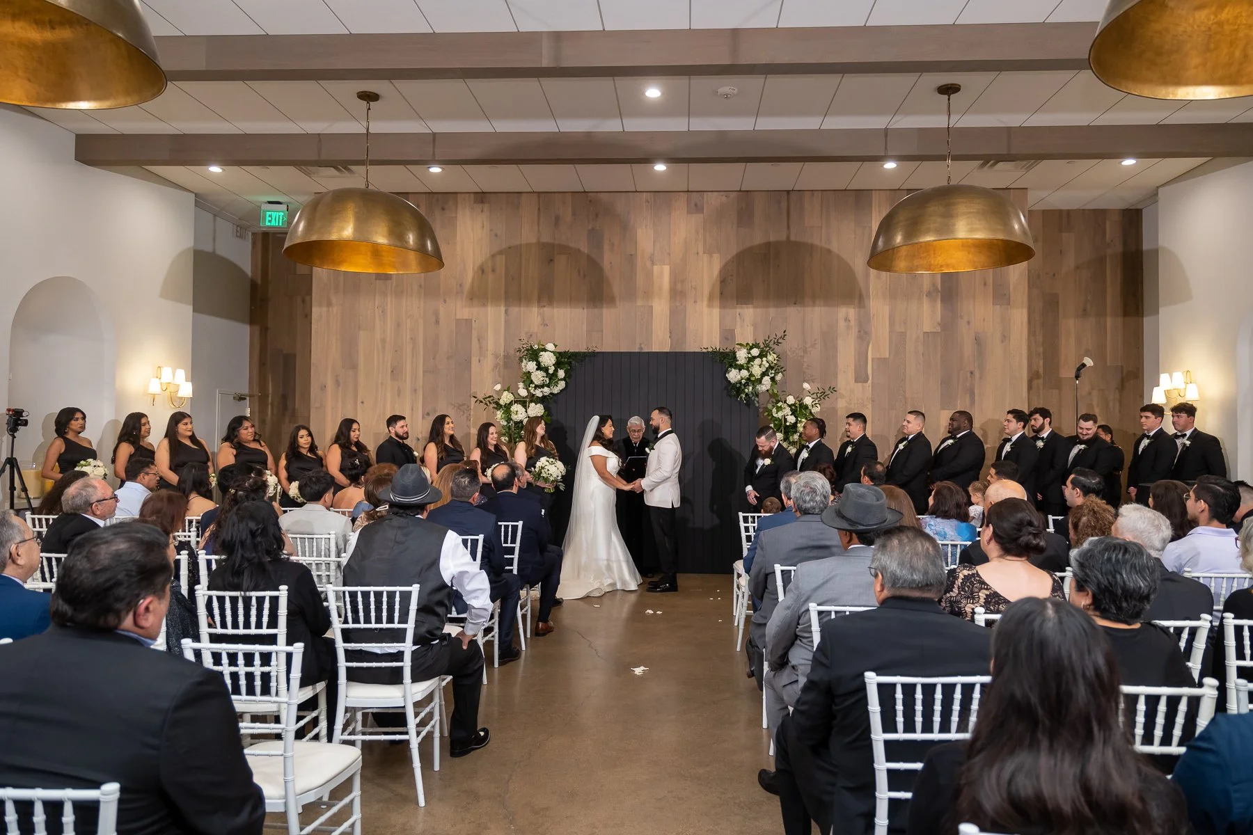 Wedding ceremony with guests and wedding party inside The Hall on Dragon in Dallas