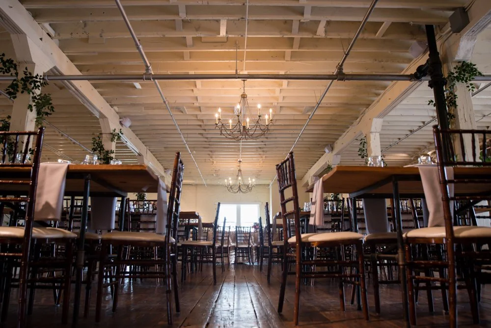 Wedding reception setup inside BRIK Venue in Fort Worth, Texas, with exposed brick and hardwood floors.