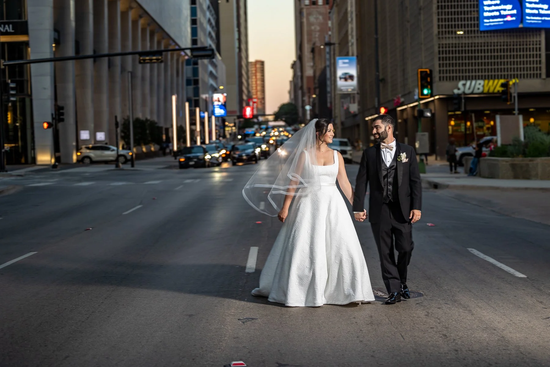 Newlywed couple walking through downtown Dallas after their Westin Dallas Downtown wedding celebration