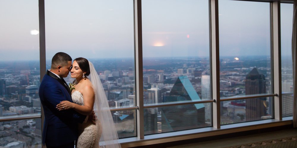 Bride and groom wedding portrait in front of the Dallas skyline at Tower Club Dallas.