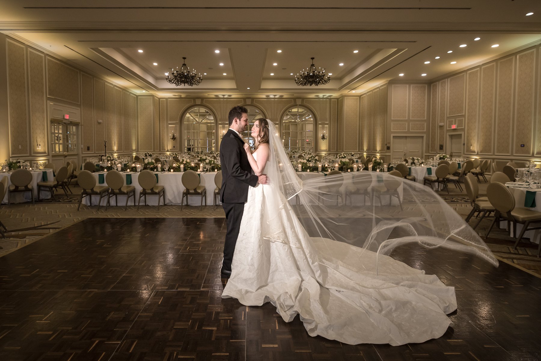 Bride and groom portrait with flowing veil inside The Adolphus wedding ballroom in Dallas