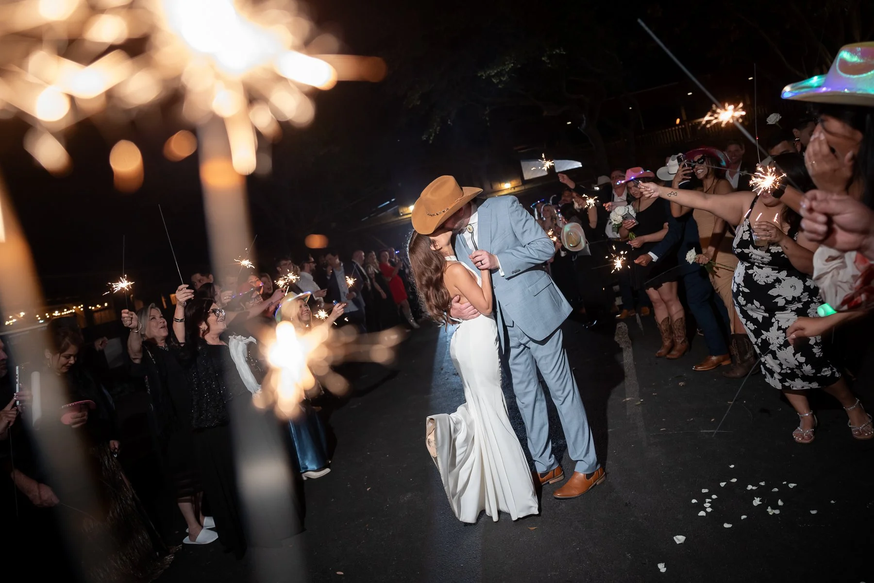 Newlywed couple sharing a kiss during a sparkler wedding exit at Lucky Spur Ranch in Justin, TX.