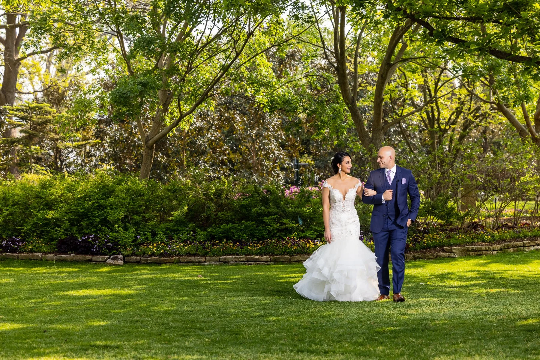 Bride and groom walking through the gardens during their Dallas Arboretum wedding in Dallas.