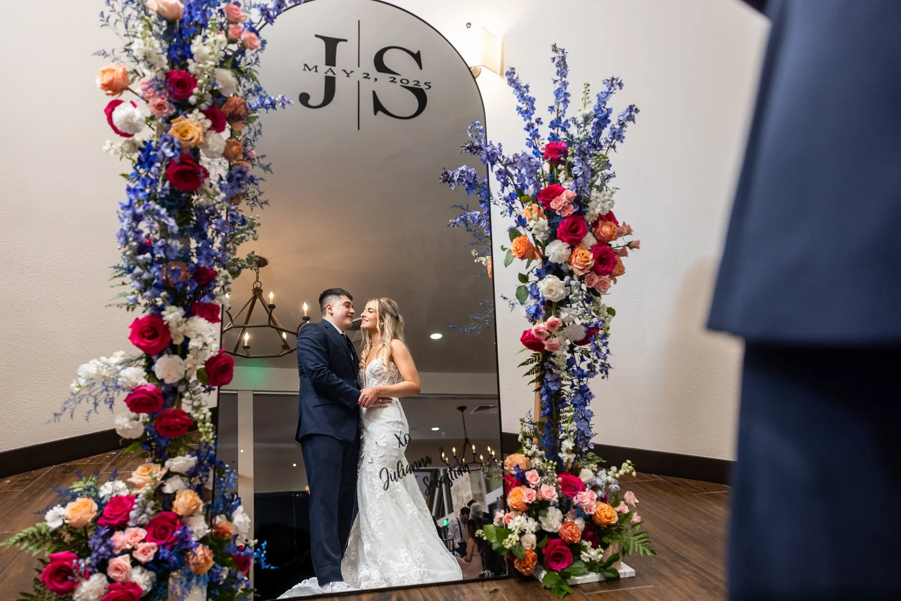 Bride and groom reflected in a floral wedding mirror at The Laurel.