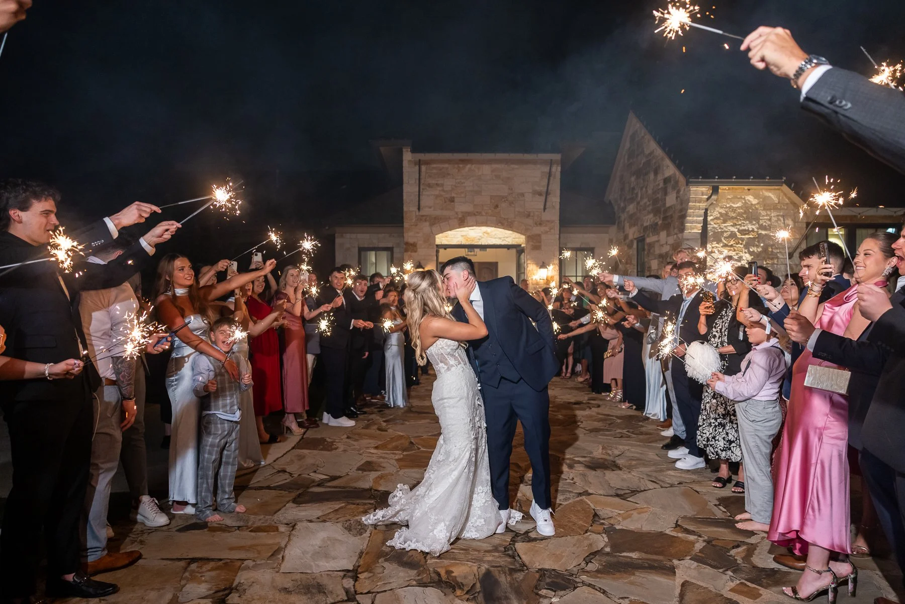 Bride and groom sharing a kiss during a sparkler exit at The Laurel.