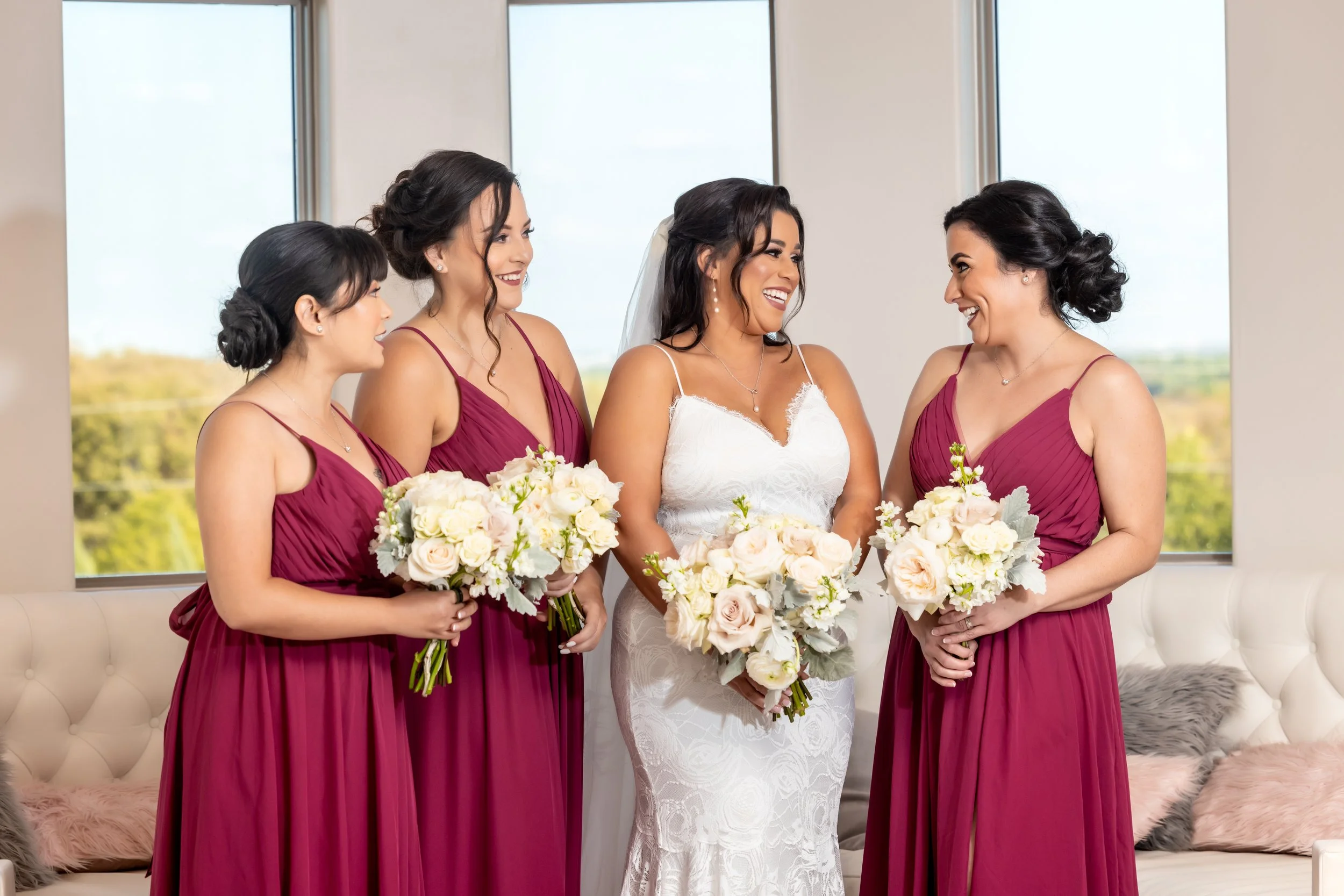 Bride and bridesmaids holding coordinated white and cream wedding bouquets.