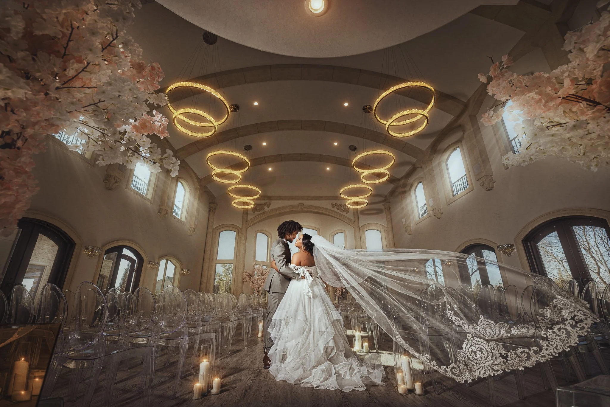 Bride and groom photographed inside an elegant wedding reception space with dramatic lighting.