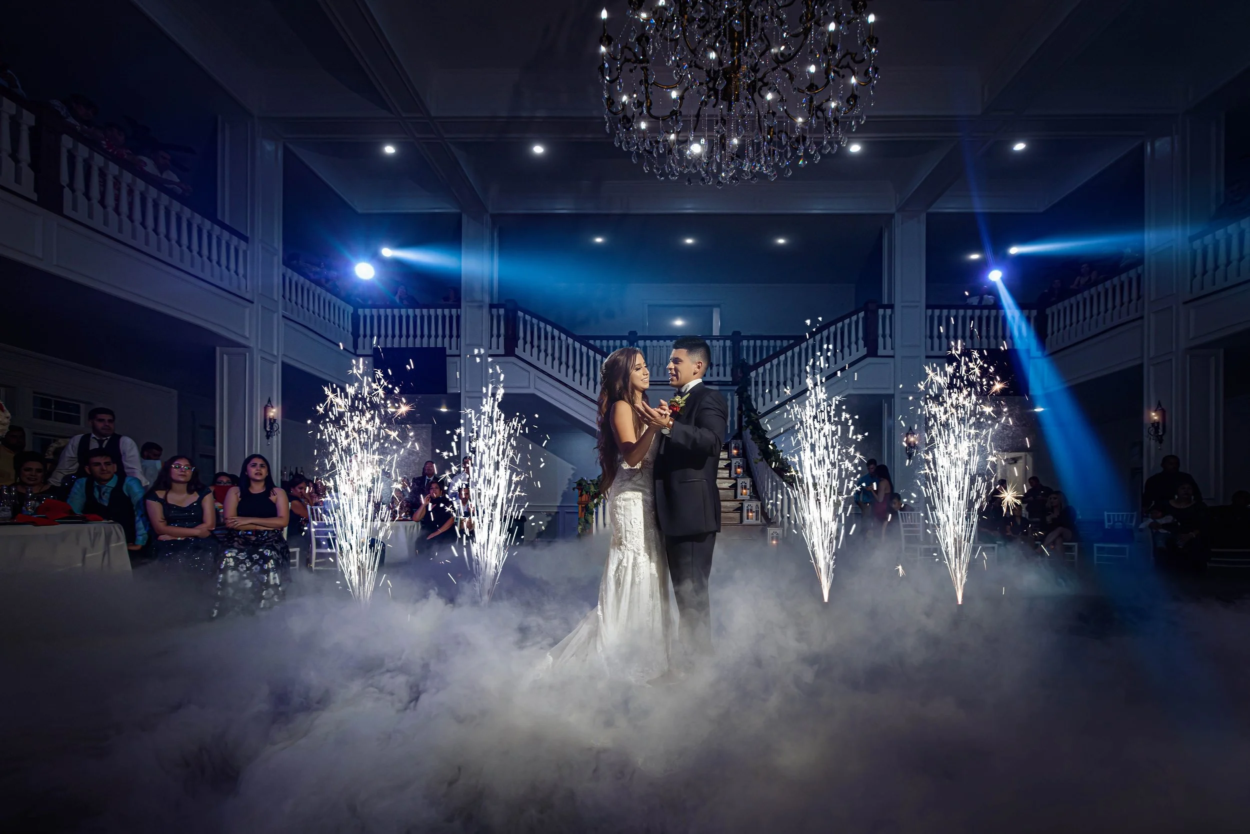 Bride and groom sharing their first dance surrounded by sparklers.
