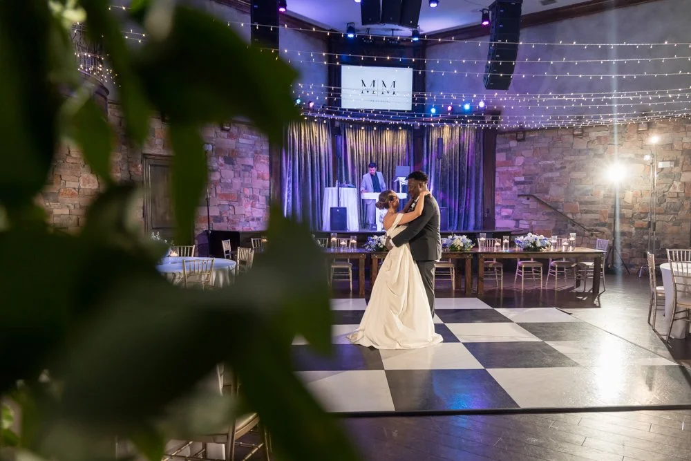 Mallory and Marcus dancing at their reception with string lights above the dance floor.