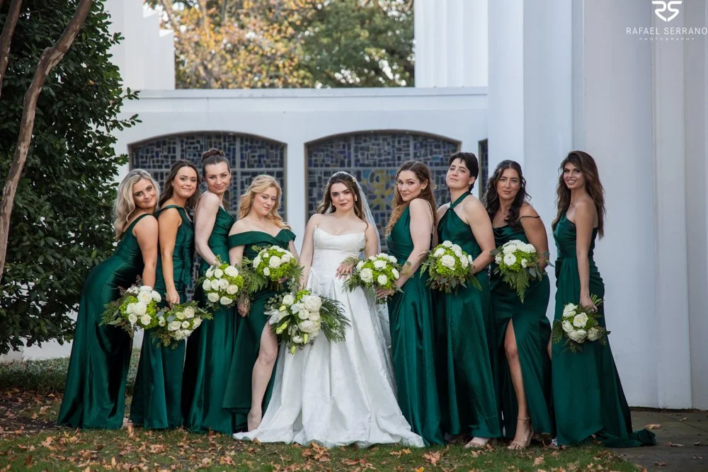 McKenna with her wedding party in emerald dresses, holding white-and-green bouquets outside the church.