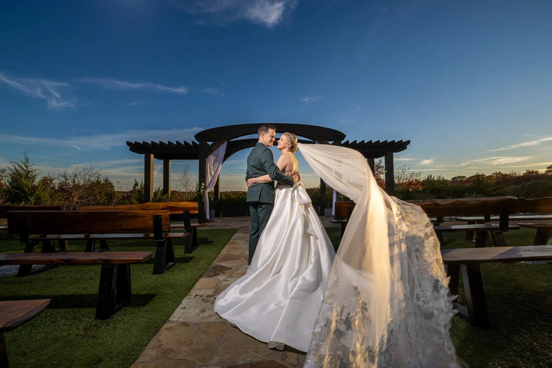 Bride and groom beneath the outdoor ceremony pergola at Stone Crest Venue near McKinney, TX.