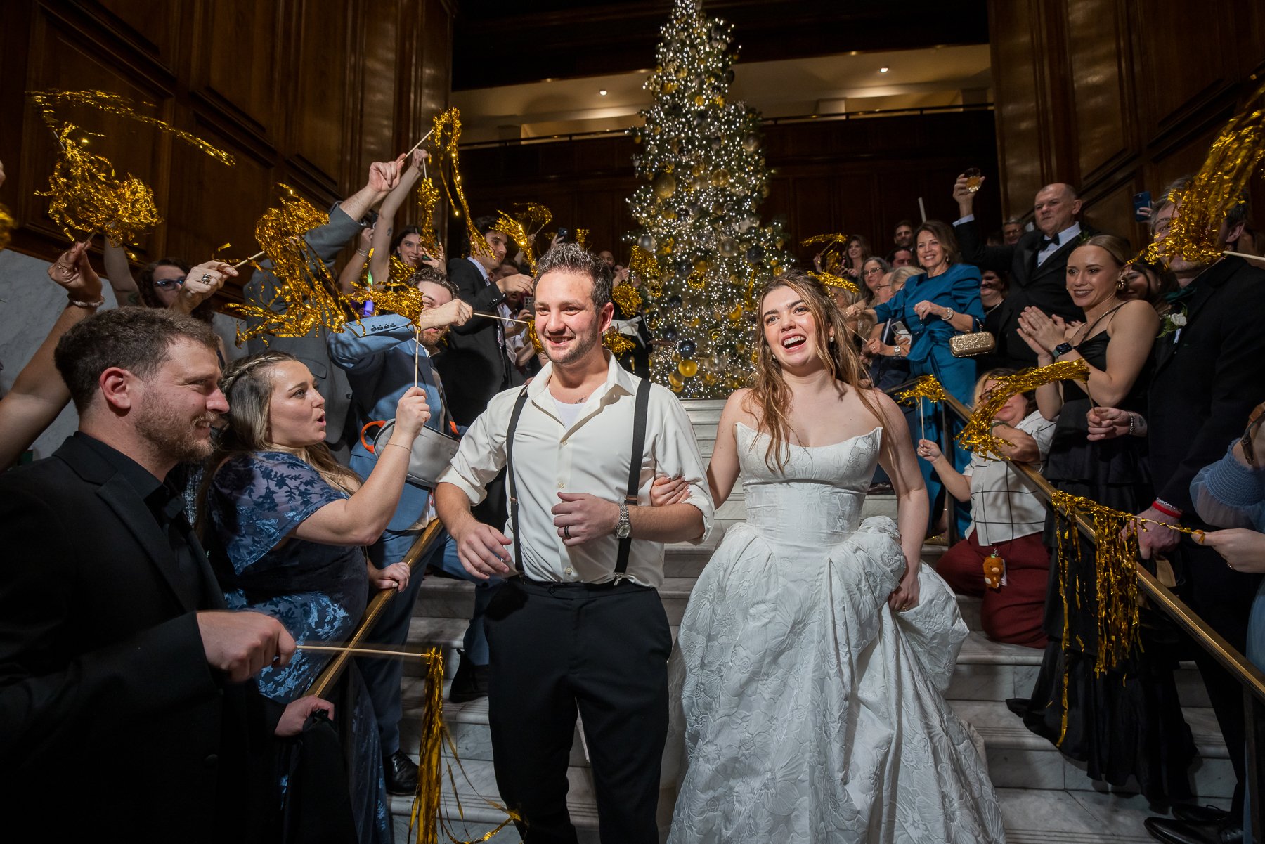 Newlyweds surrounded by family and friends during their wedding exit at The Adolphus Hotel in Dallas