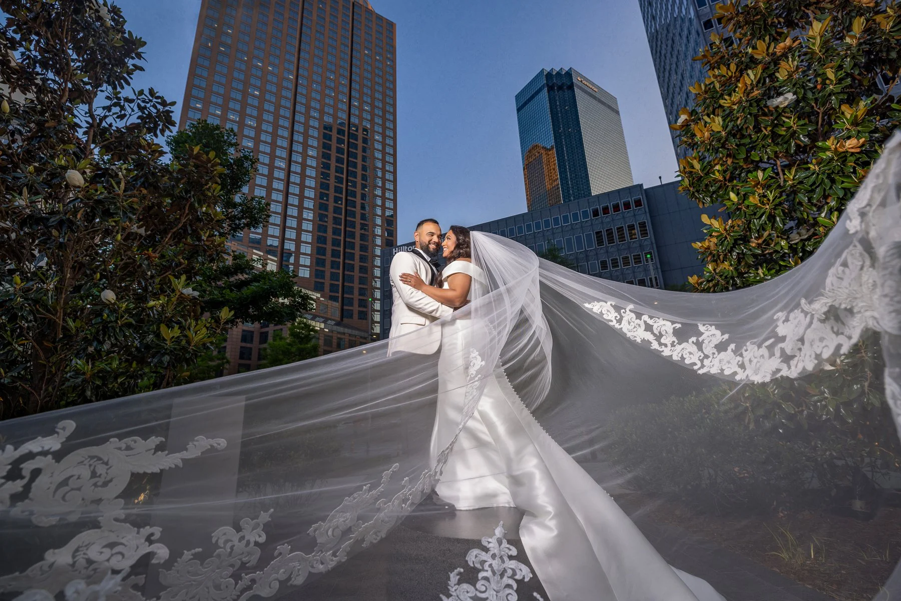 Creative wedding portrait of a bride and groom using the bride's veil near The Hall on Dragon