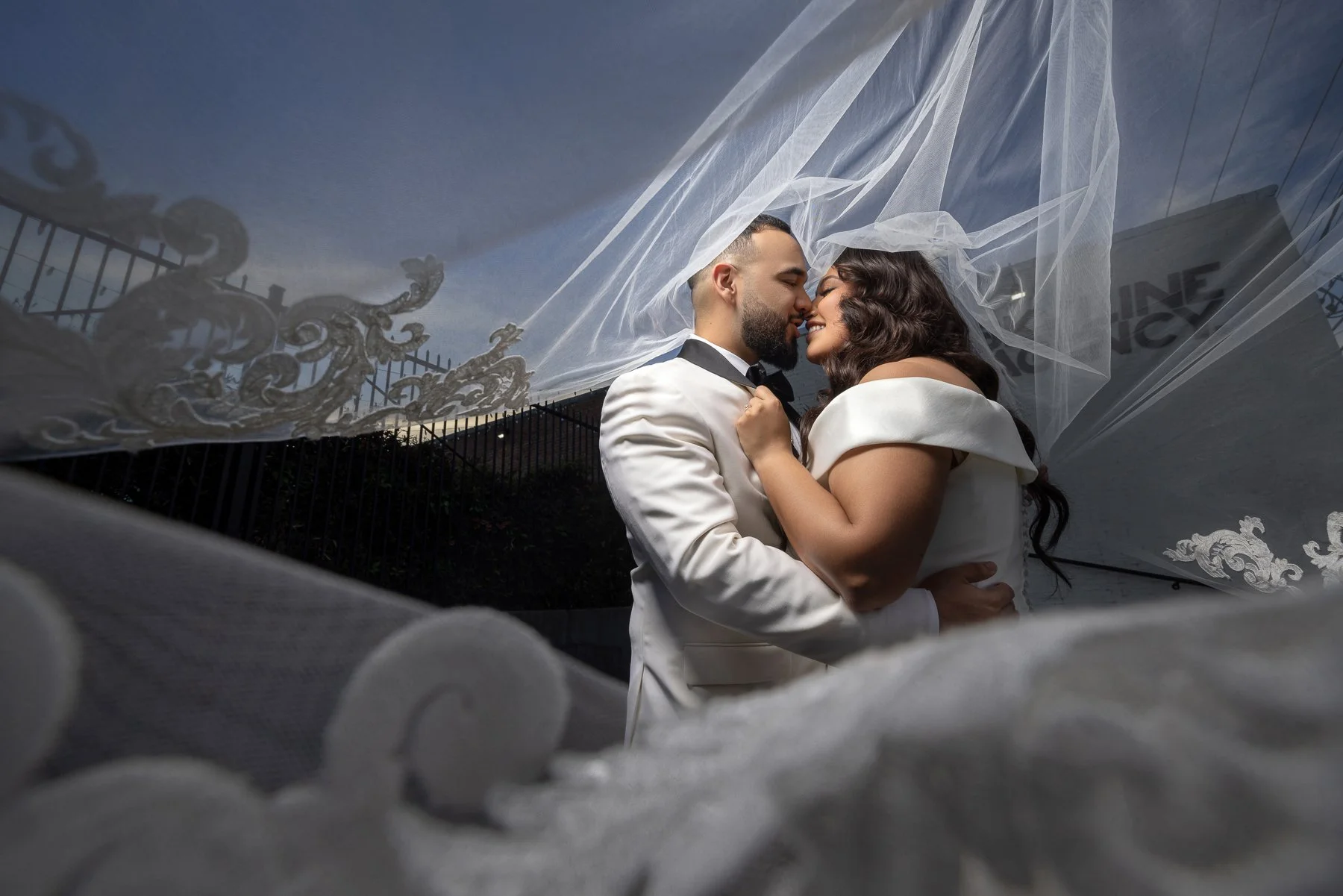Bride and groom with a flowing veil during a sunset wedding portrait near The Hall on Dragon in Dallas
