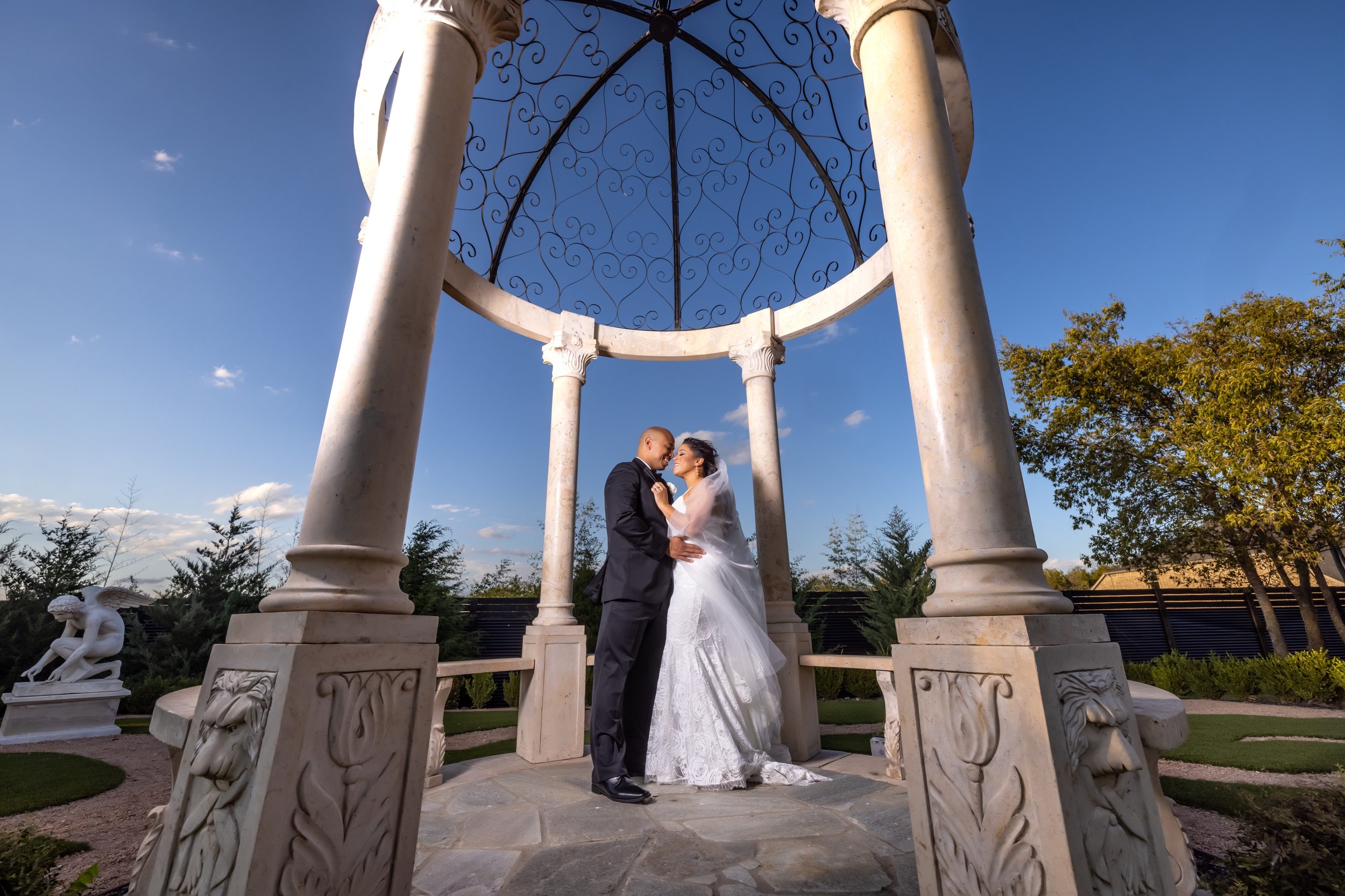 Bride and groom wedding portrait beneath the outdoor gazebo at Knotting Hill Place in Little Elm, Texas.