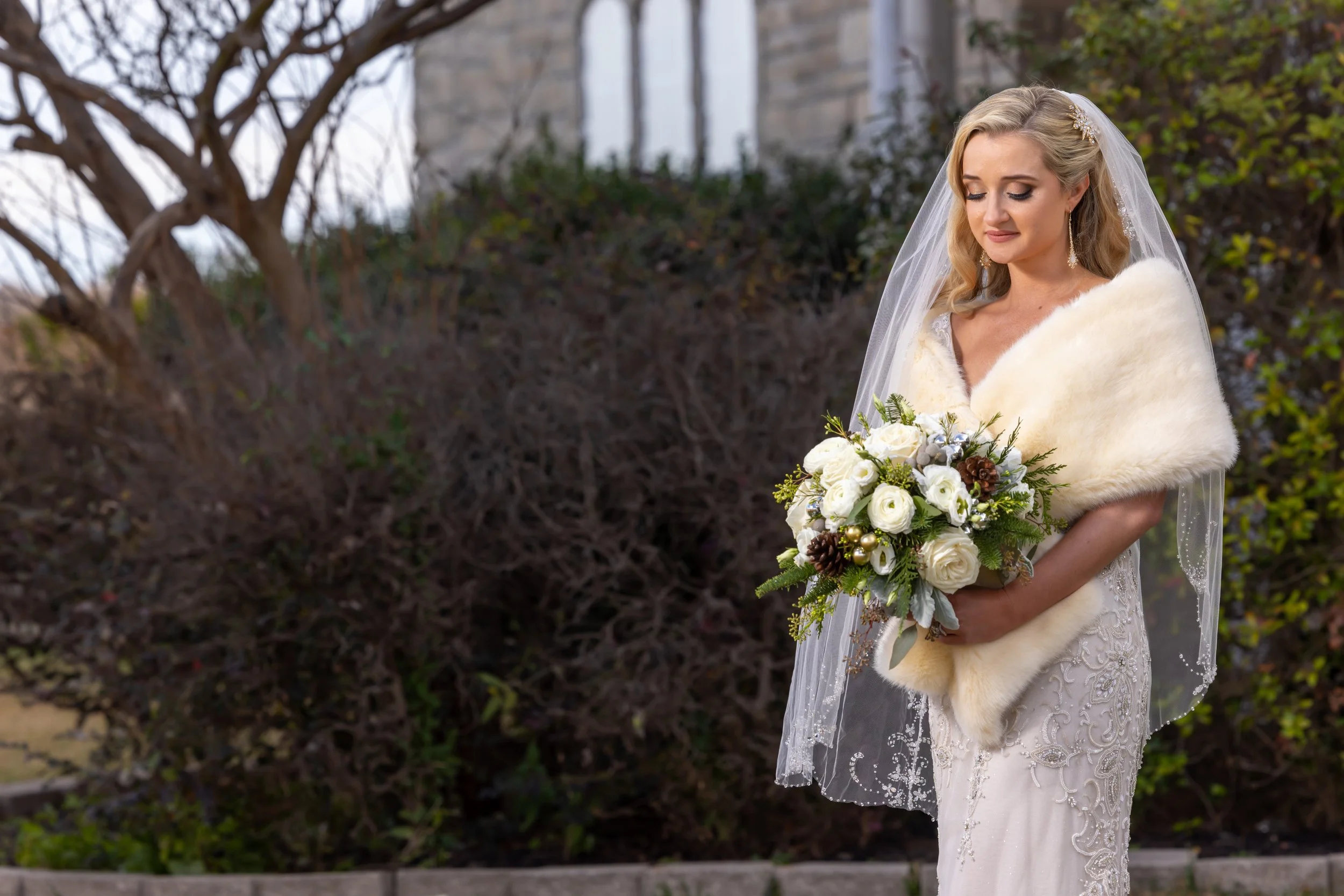 Bride holding a full white and green wedding bouquet.