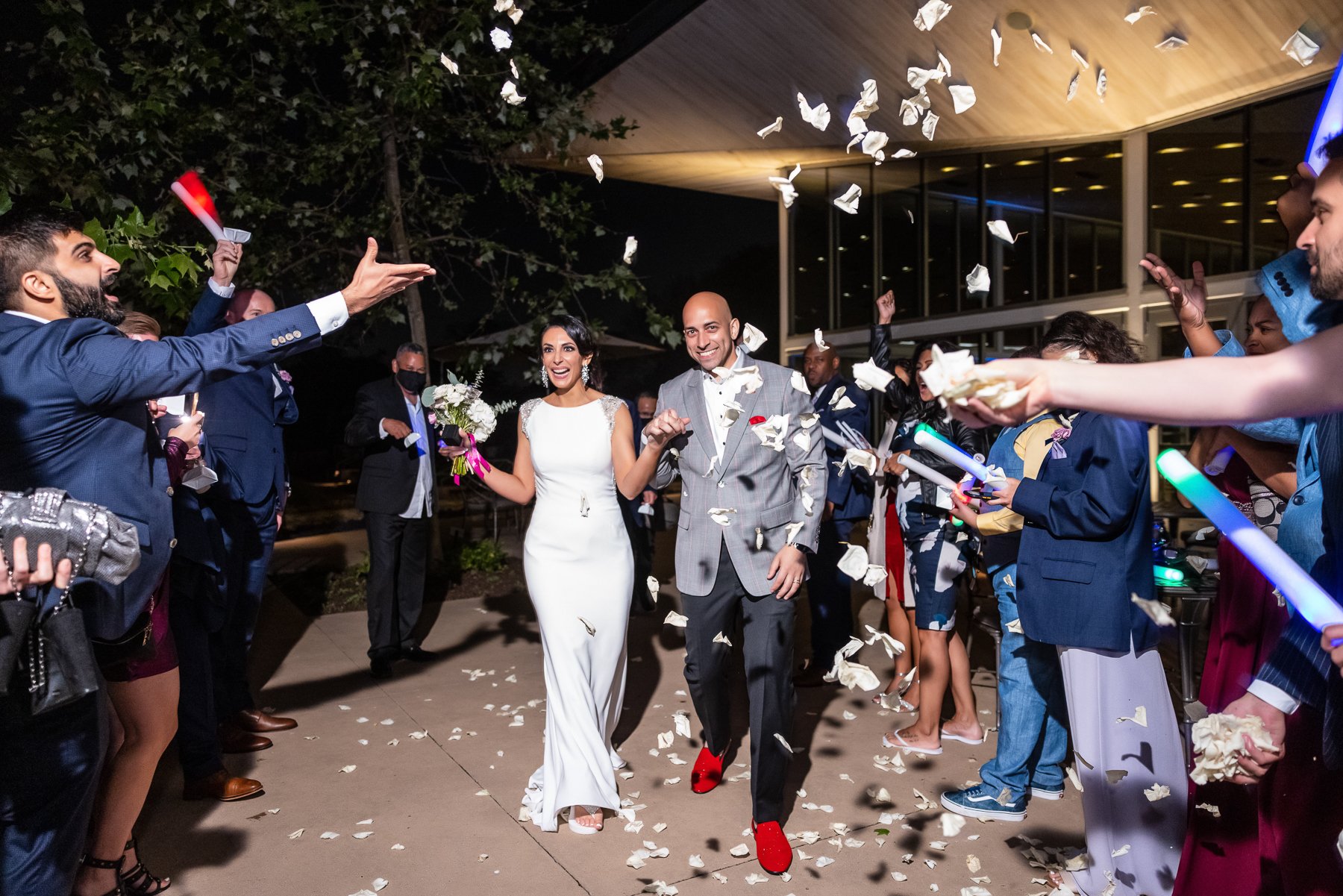 Bride and groom celebrating during their nighttime wedding exit at the Dallas Arboretum in Dallas.