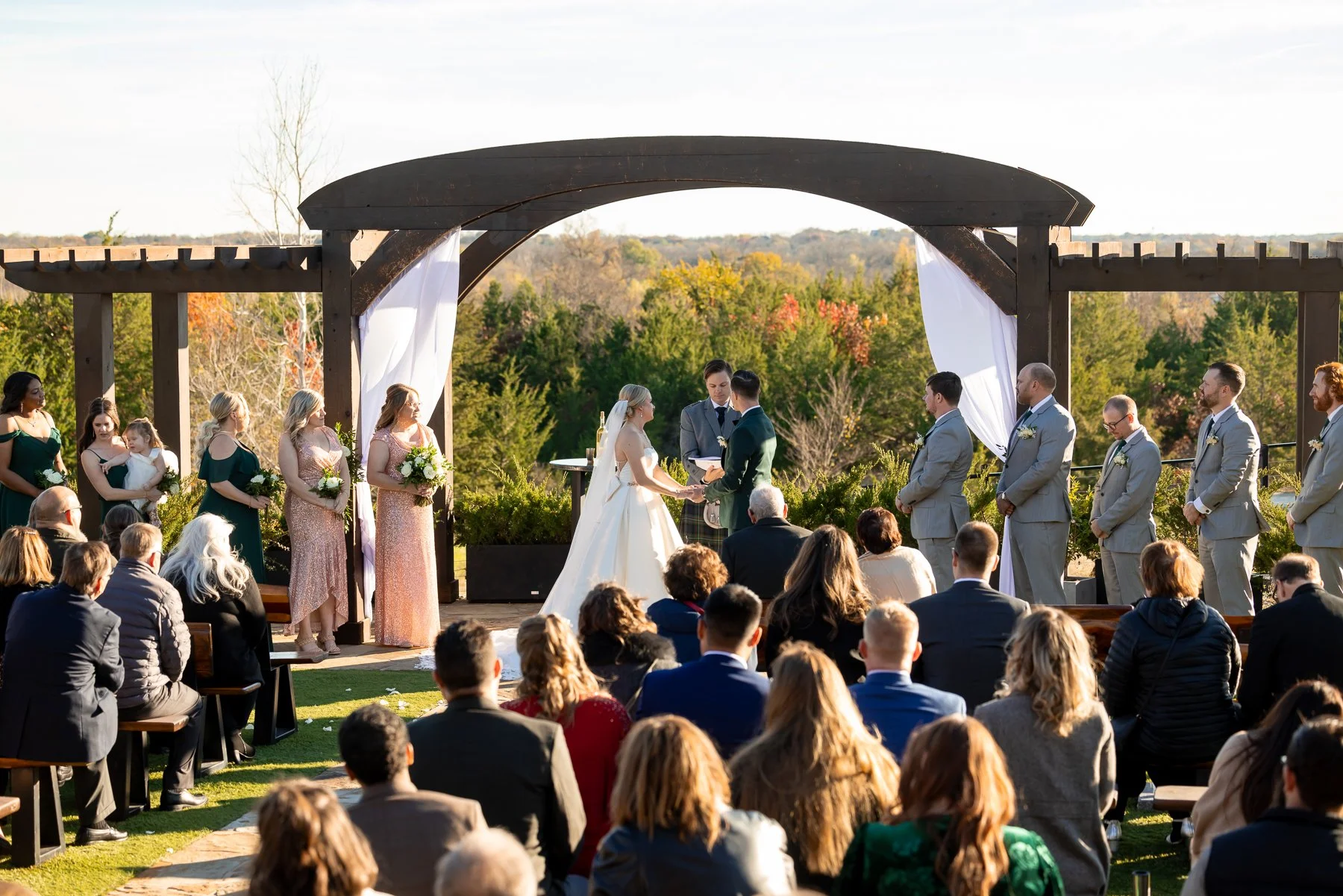 Wedding ceremony photographed beneath the outdoor arbor at Stone Crest Venue near McKinney, TX.