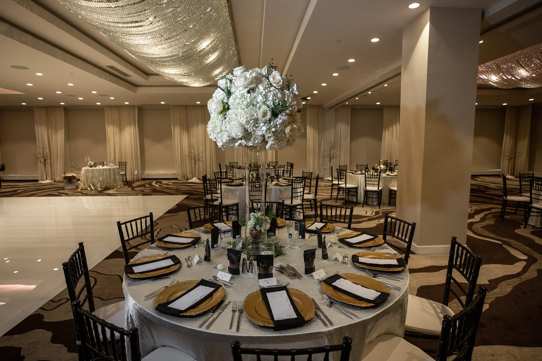 Elegant wedding ceremony setup with white florals and a suspended floral installation at The Westin Dallas Downtown