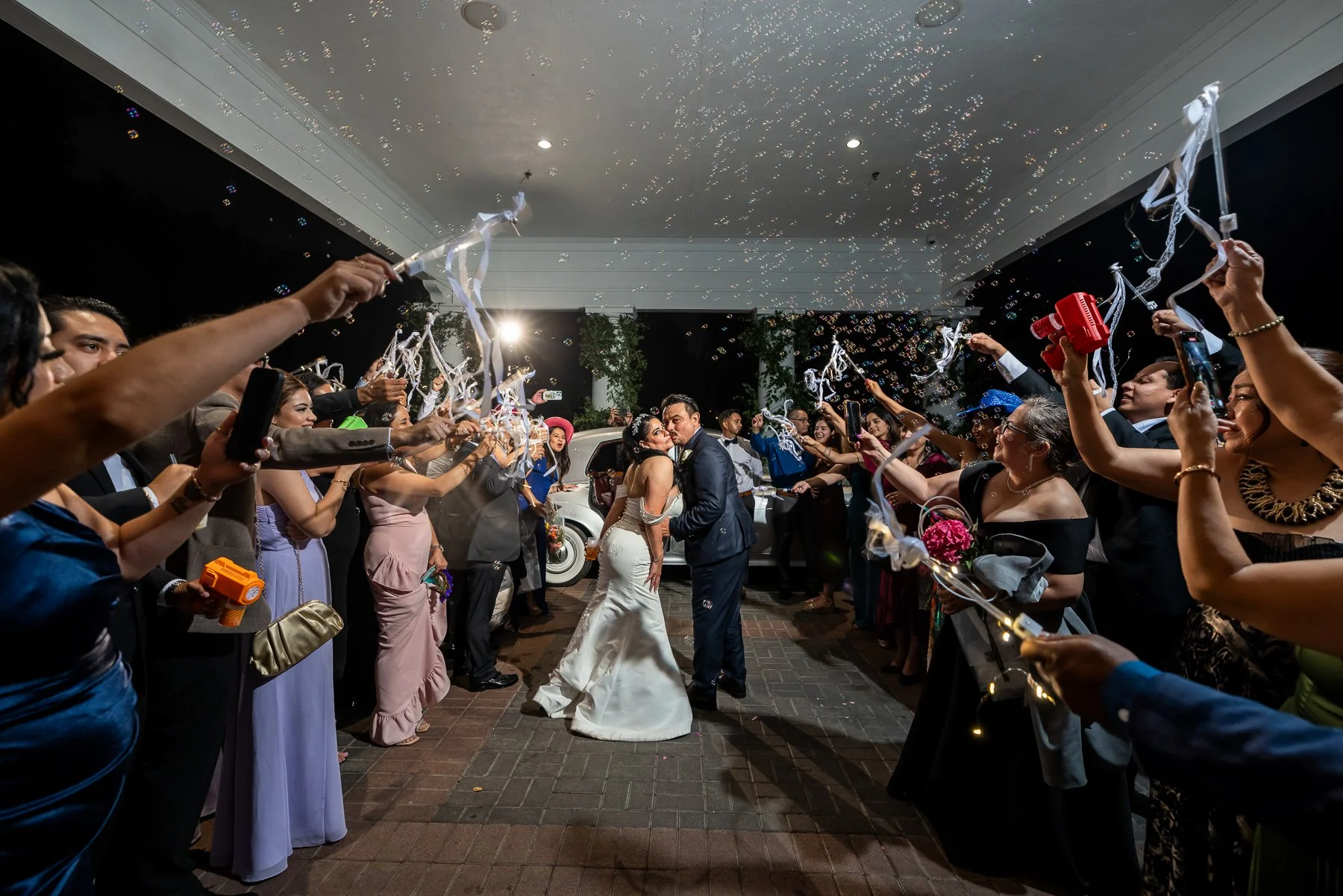 Bride and groom kissing during their wedding exit at Arlington Hall in Dallas