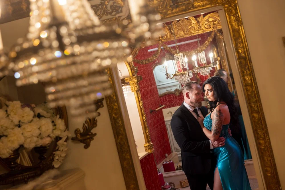 Angled couple portrait framed through decorative foreground details.