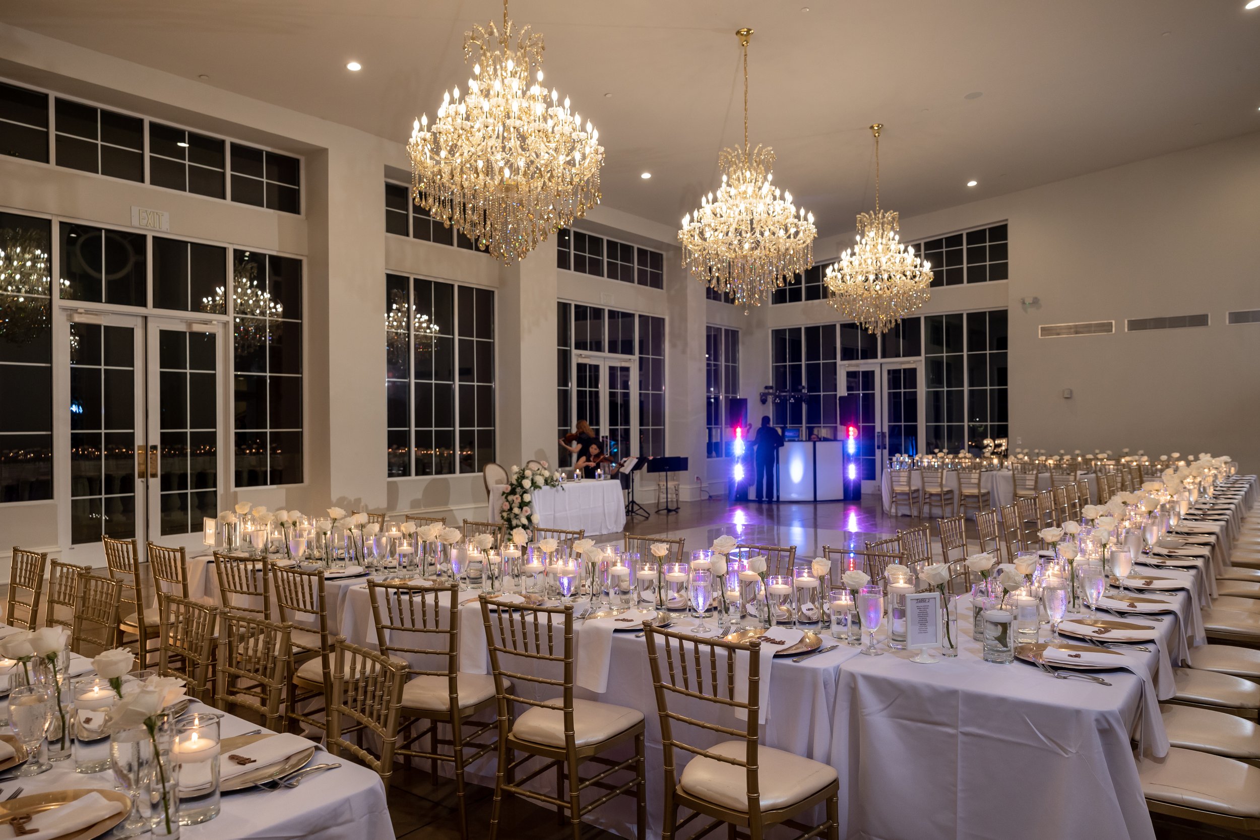 Elegant wedding reception setup with decorated tables, chandeliers, and entertainment area in Dallas, Texas.